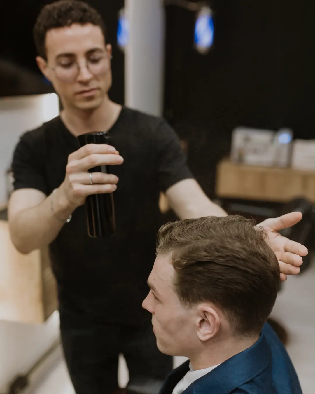João, dono da Barbearia Wolf, finalizando o penteado de um cliente